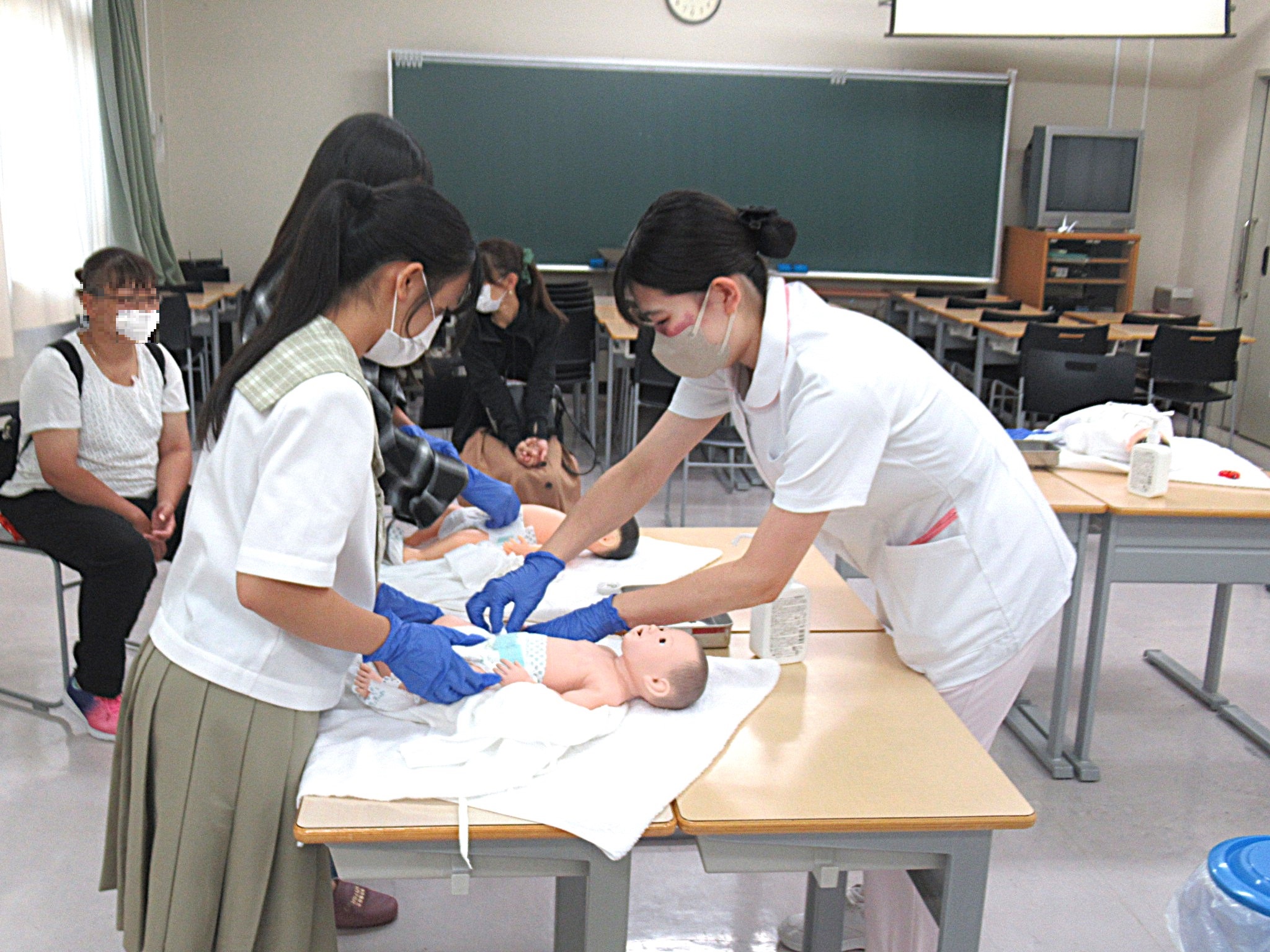 学生と着替えやおむつ交換を行いました（新生児援助体験）